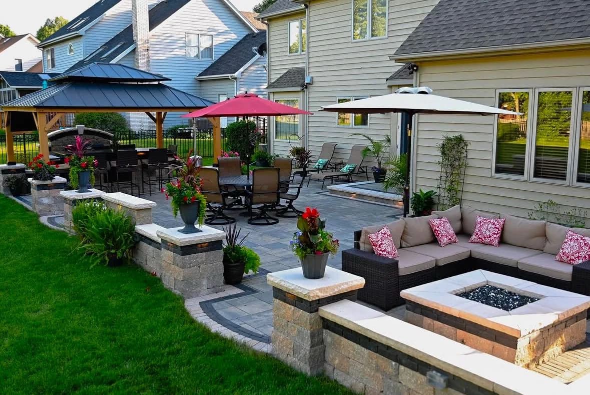 Landscaped backyard with a paved lounge area, raised deck and garden beds